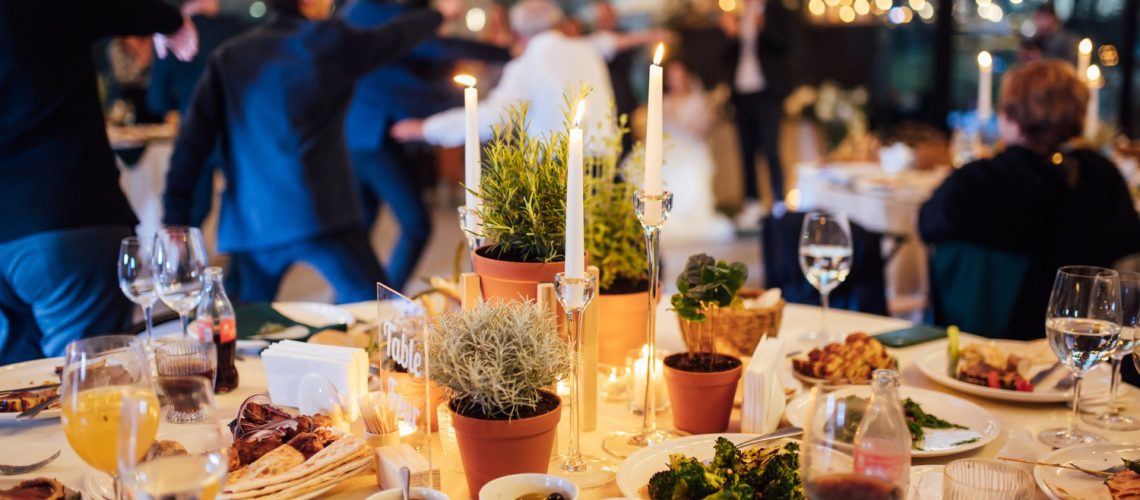 flower-candle-decoration-wedding-against-background-dancing-guests